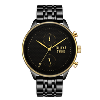 Pharaoh watch featuring a black dial, gold accents, and a black metal bracelet on a red background.