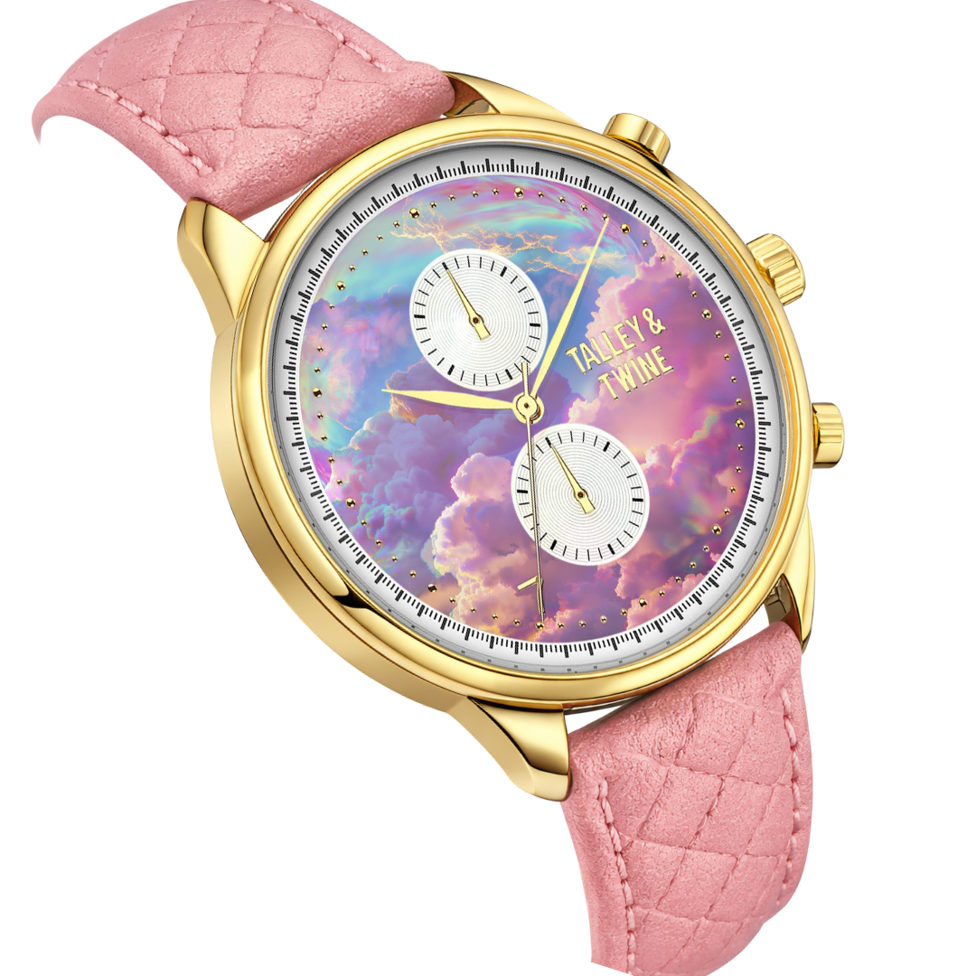 Pink unicorn watch with a gold case, pink quilted strap, and a colorful cloud-patterned dial featuring two subdials.