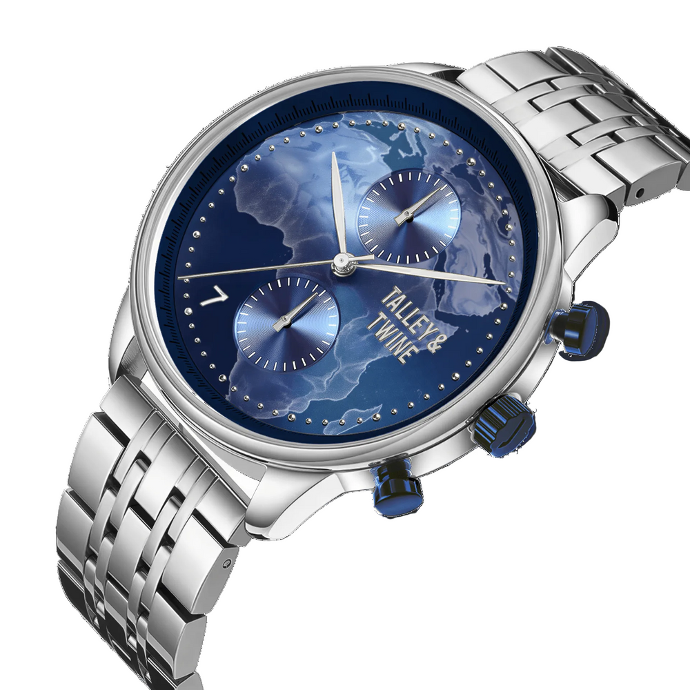Origins watch with a blue globe dial, silver stainless steel band, and two chronograph subdials.