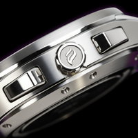Talley & Twine Close-up of a silver watch with a brand logo on a dark background